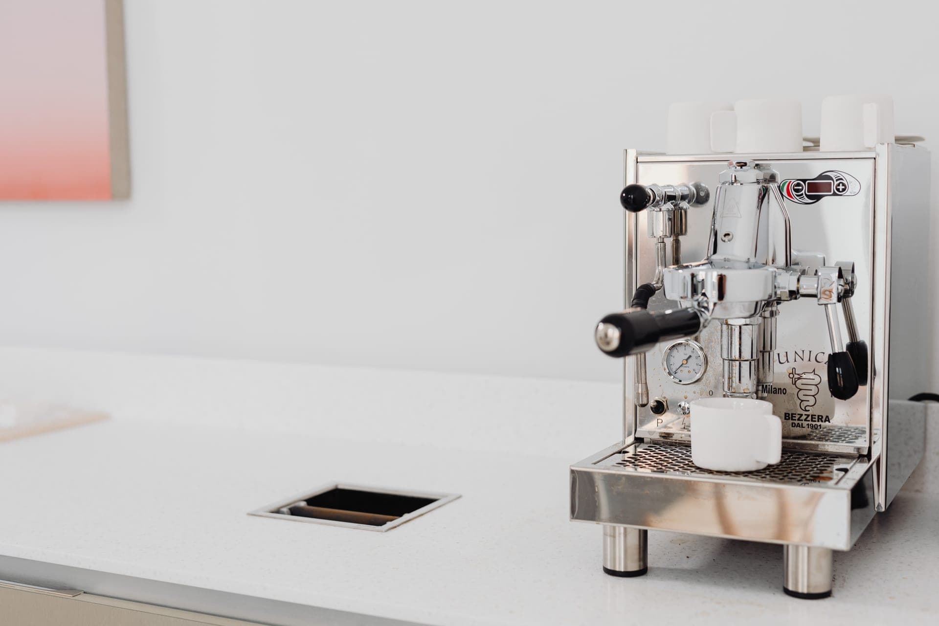 A stainless home espresso machine with a portafilter locked into the group head