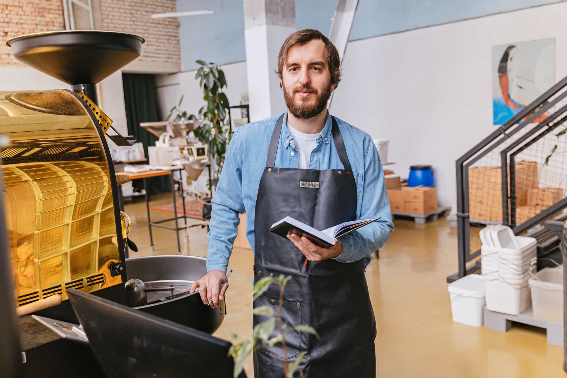 A notebook and coffee equipment on a counter during a brewing session